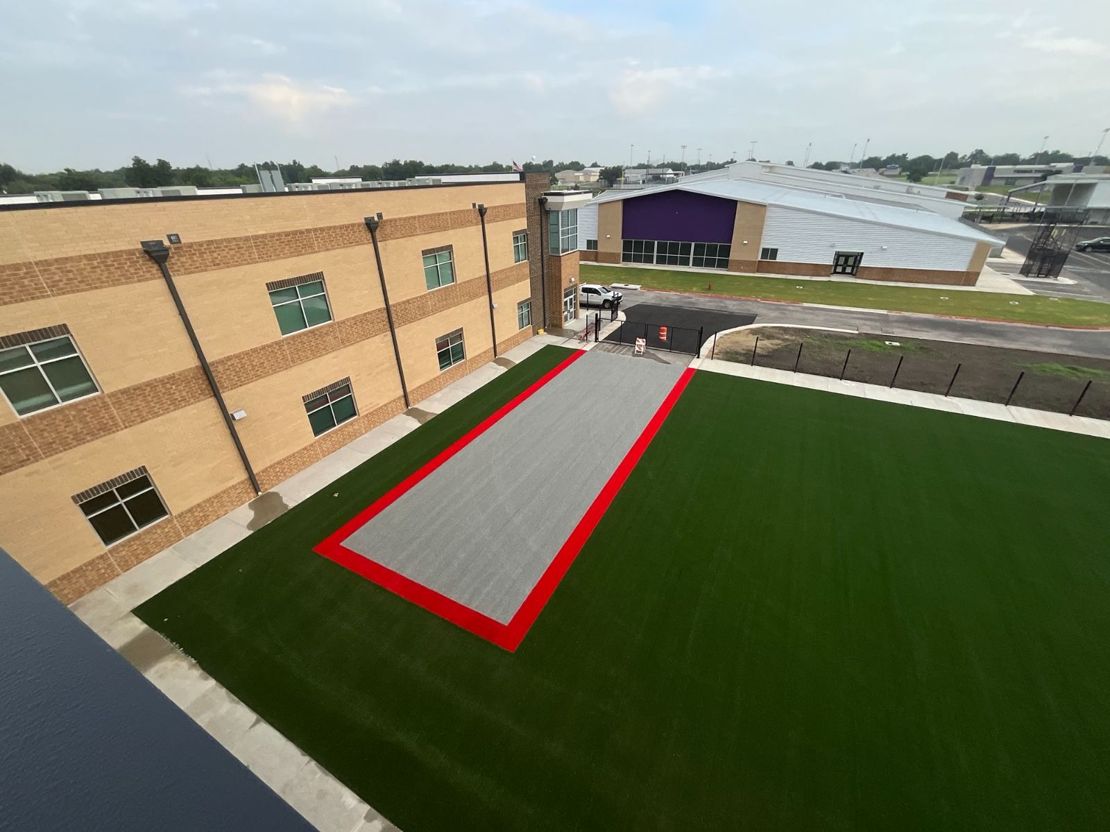 Courtyard with artificial turf beside the two-story classroom wing